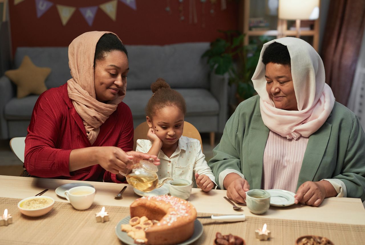 A happy family enjoying tea and cake indoors, fostering warmth and togetherness.